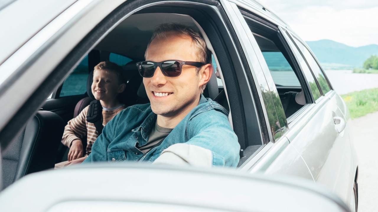 Papà e figlio in auto con finestrino abbassato