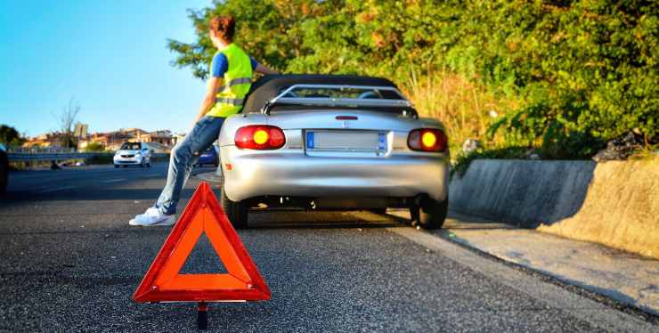 Ragazza con auto in panne aspetta i soccorsi