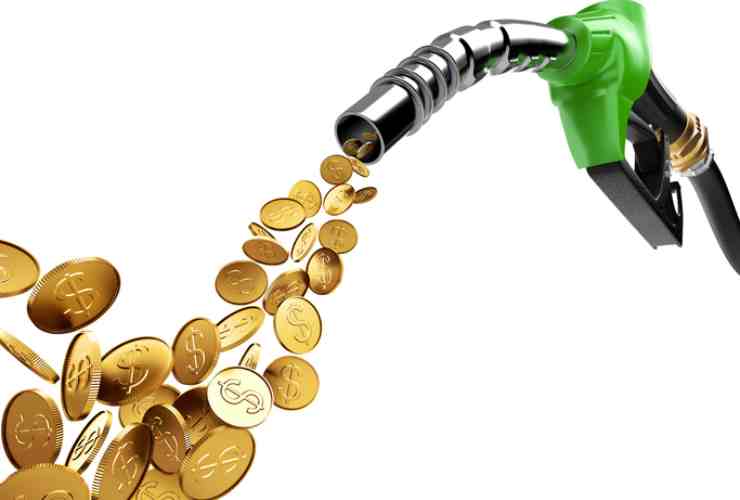 Soldi che fuoriescono da una pompa di benzina