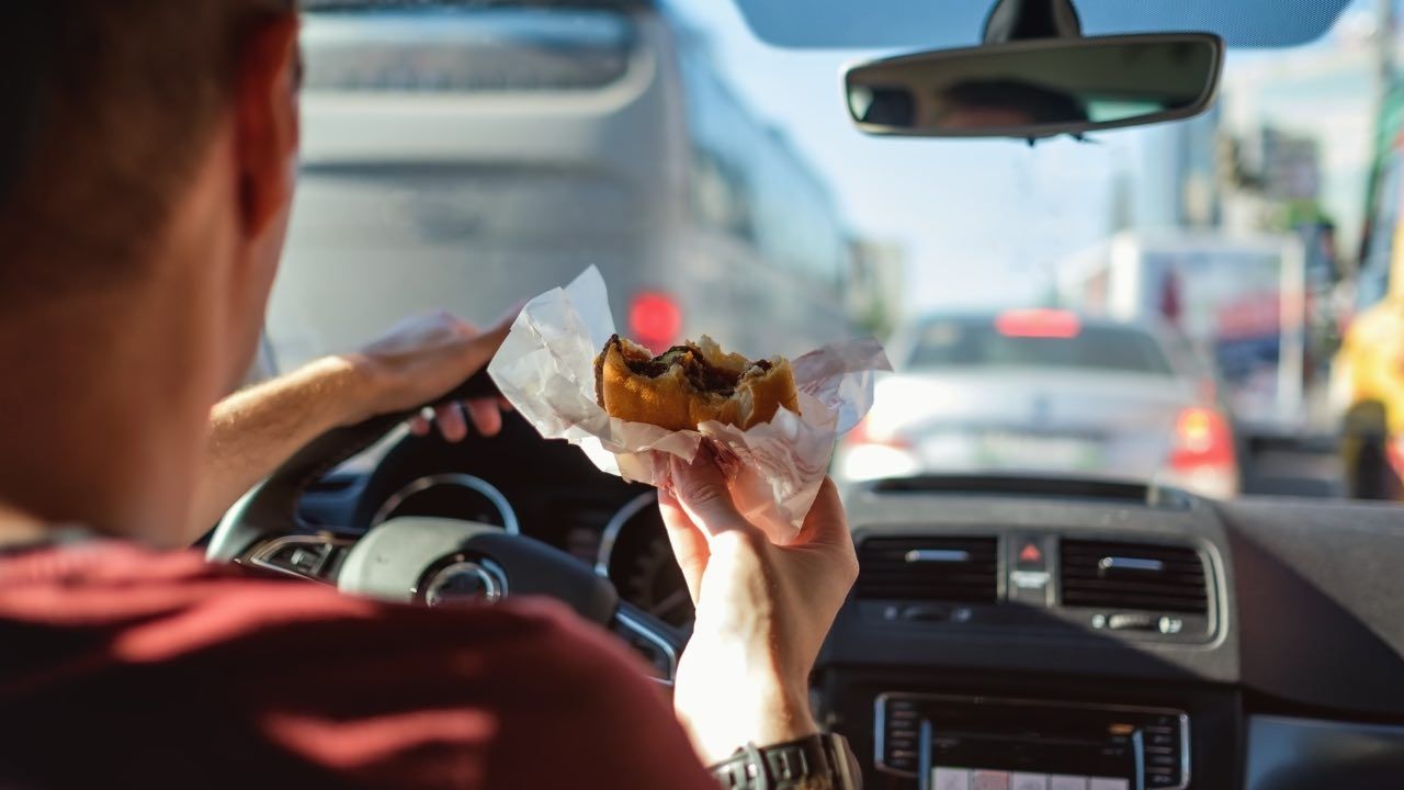 Uomo che mangia in auto